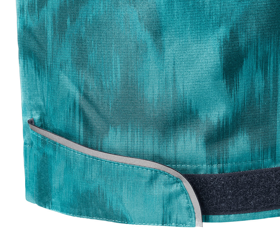 Detail celoplošne potlačených nohavíc do dažďa s reflexnými prvkami a zapínaním na suchý zips.