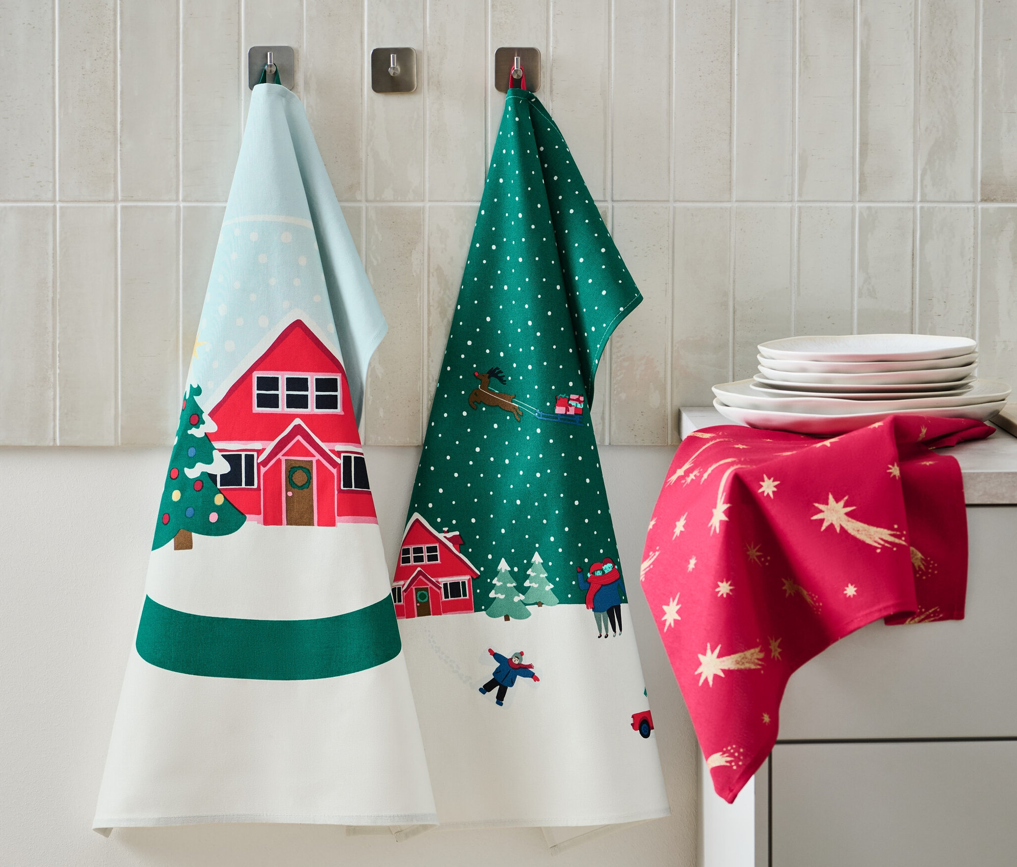 Na stene visia 3 utierky s vianočnými motívmi. Na linke ležia taniere a dávkovač mydla.