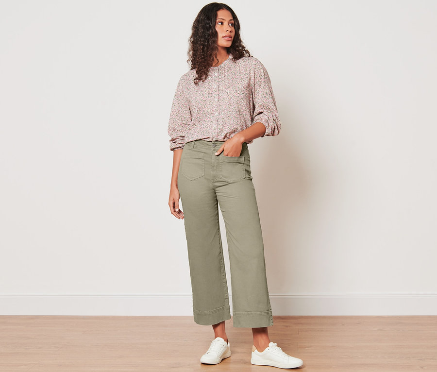 Žena stojí a pózuje v moderných džínsoch.