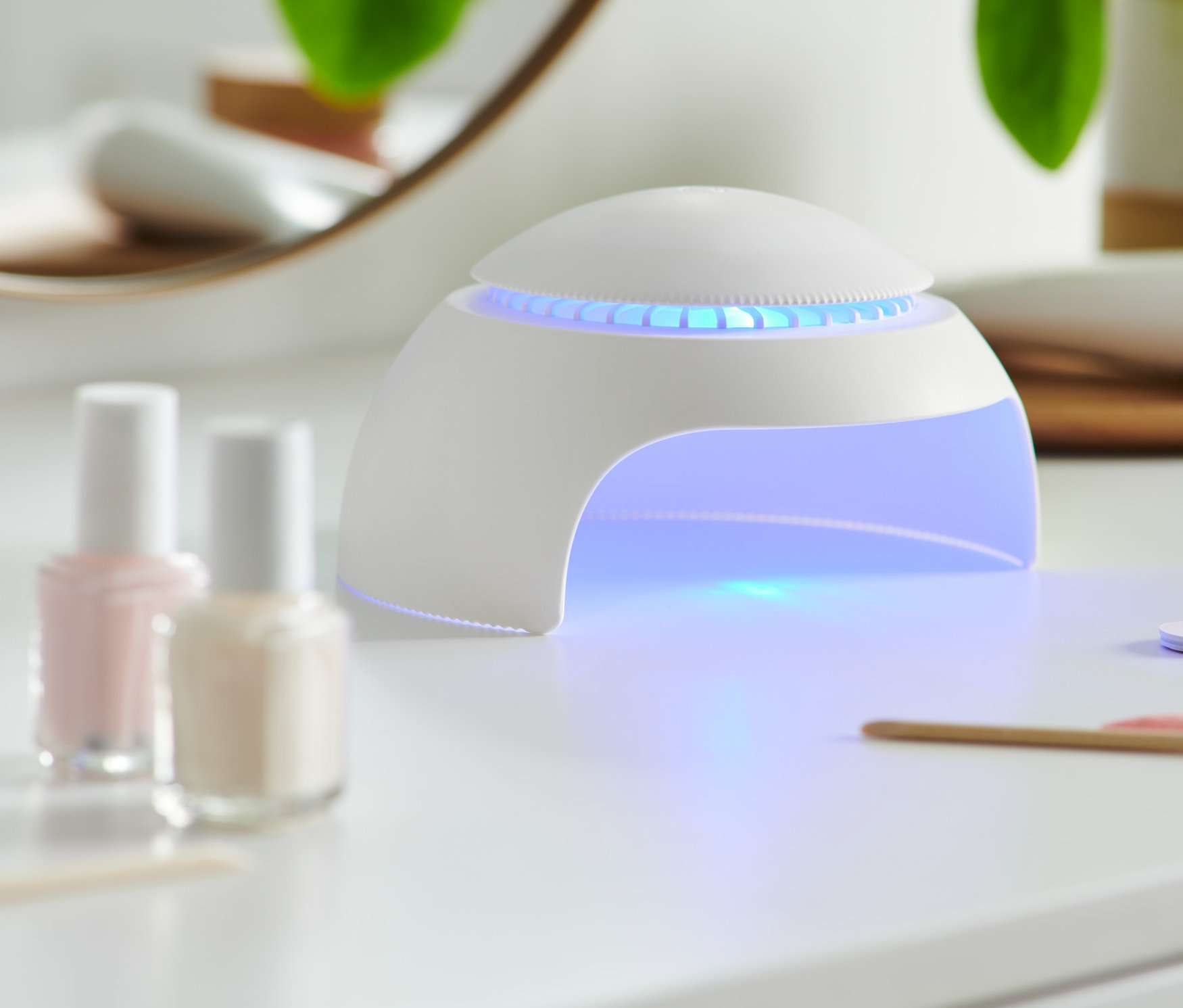 Sušička nechtov s LED svetlom a ventilátorom na bielom stole.