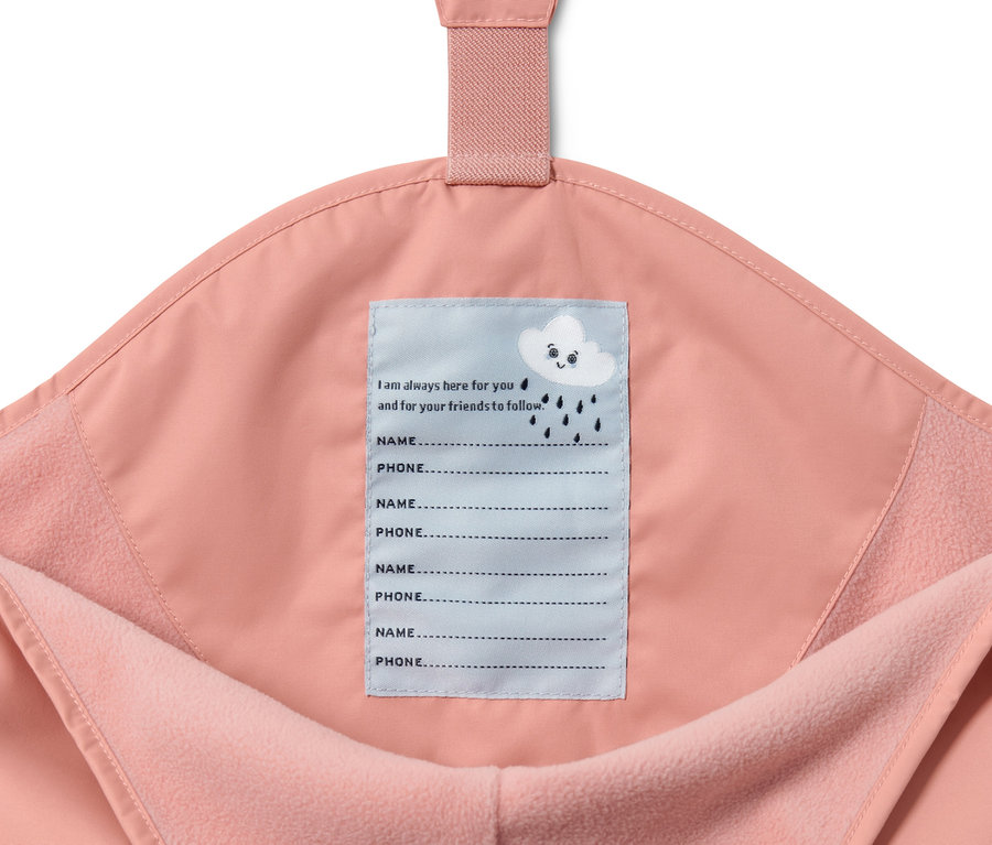 Detail ružových detských termo nohavíc do dažďa s vnútornou etiketou na meno a telefónne číslo.