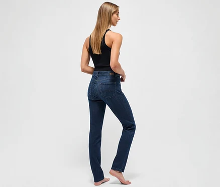 Žena stojí chrbtom a má na sebe tmavomodré džínsy Angels »Cici« strih Slim Fit a čierne tielko.
