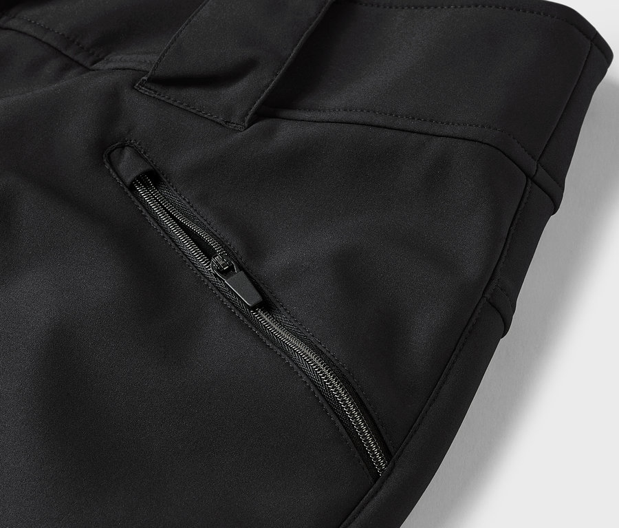 Detail čiernych nohavíc s vreckom na zips.