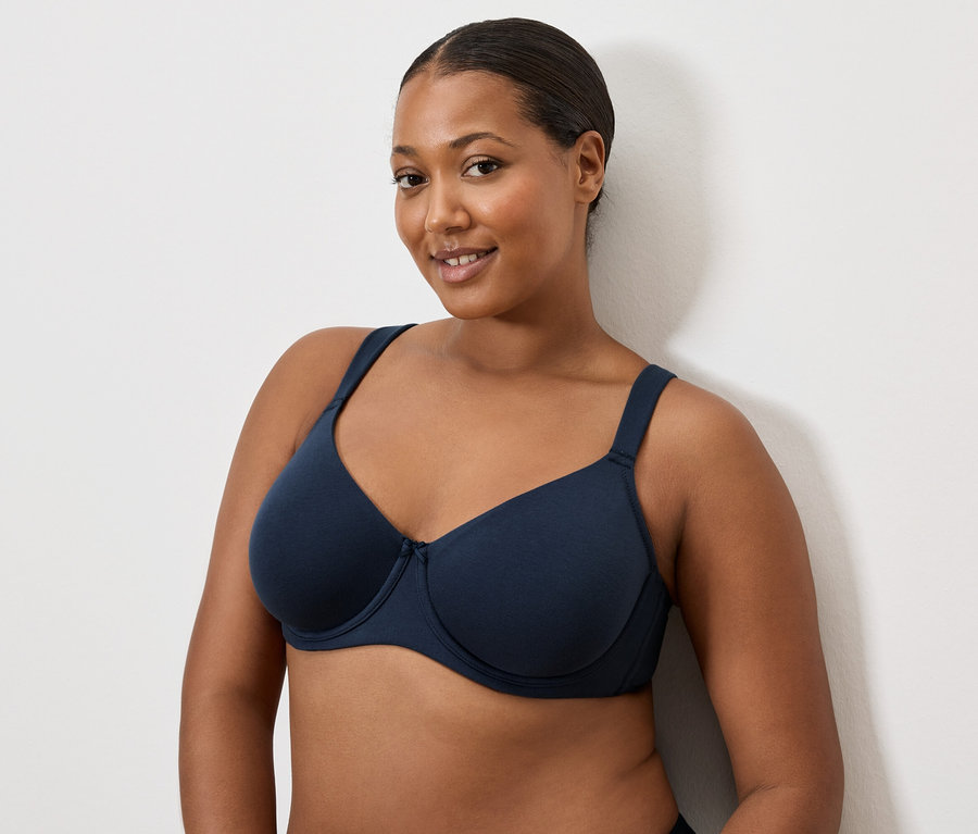Žena s tmavými vlasmi má na sebe tmavomodrú podprsenku.
