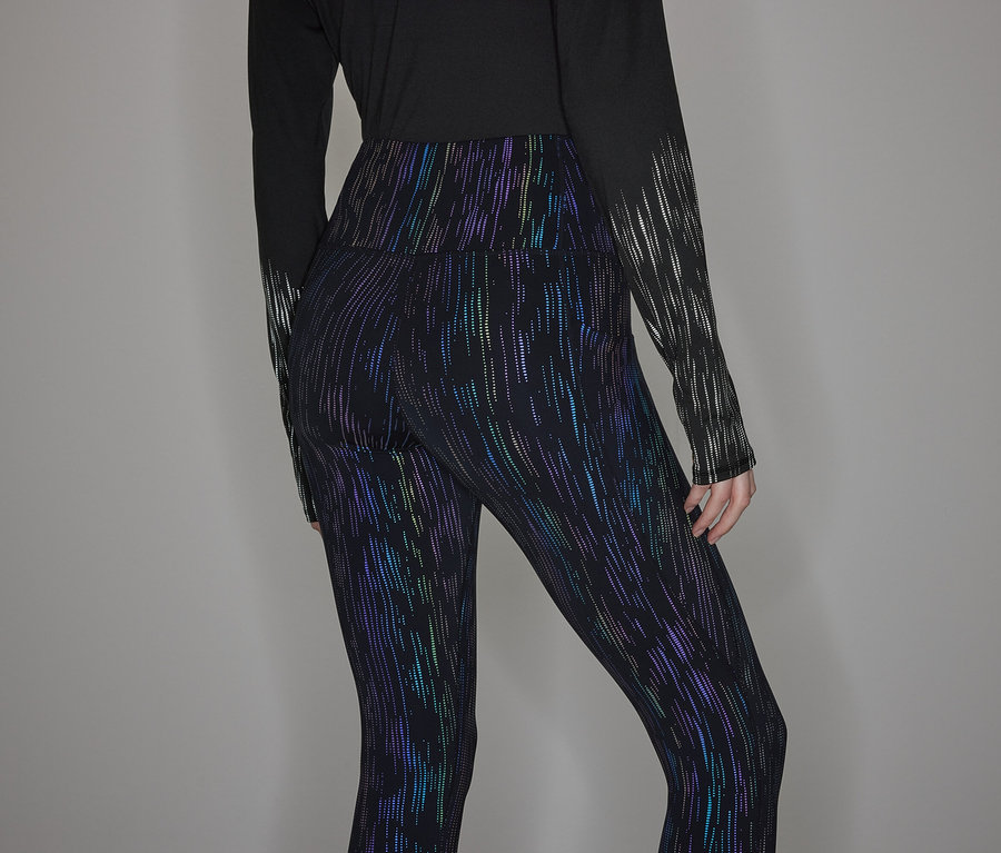 Osoba má na sebe čierne tričko s dlhým rukávom a lesklé legíny.