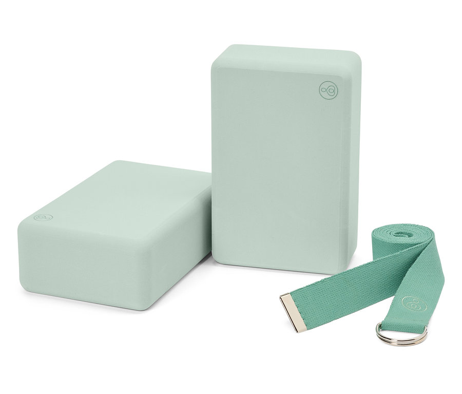 Dva svetlozelené jógové bloky a zodpovedajúci popruh.