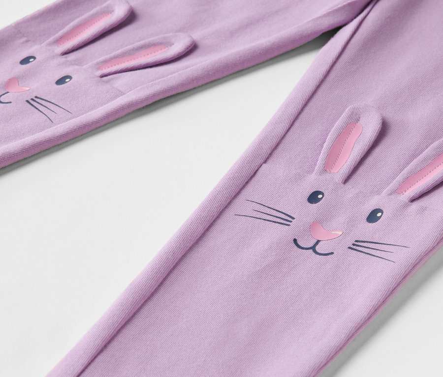 Detail fialových legín s tvárou králika s 3D ušami.