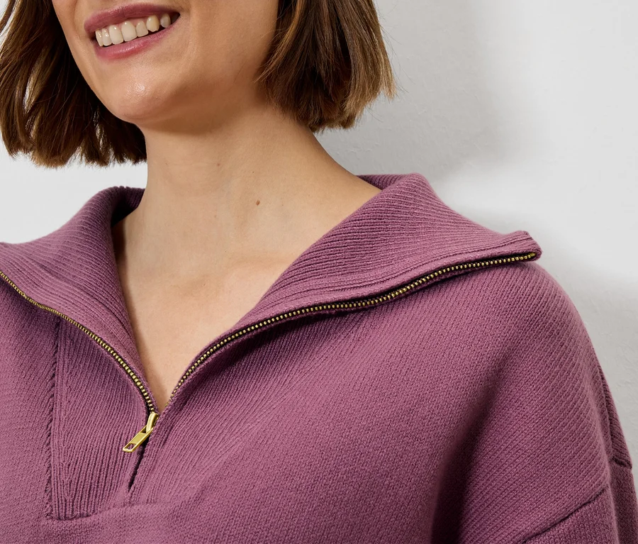 Detailný záber ženy v lila svetri na zips.