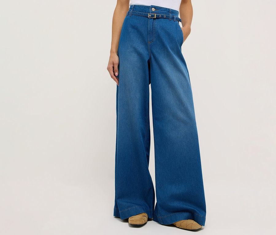 Osoba má na sebe džínsy Angels Denim »Liva« Sleek Wide Leg a hnedé topánky na bielom pozadí.