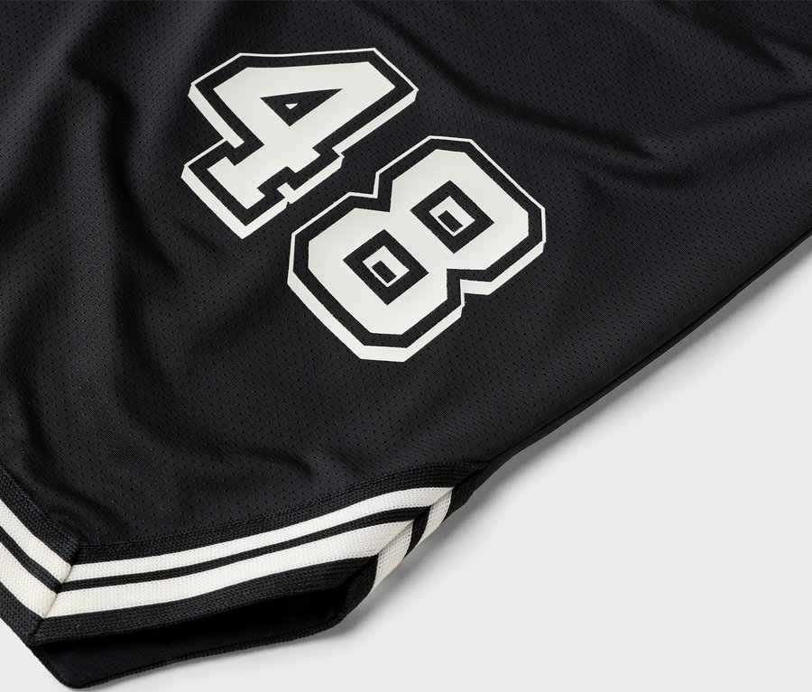 Detailný záber na čierne basketbalové šortky s bielym číslom 48.