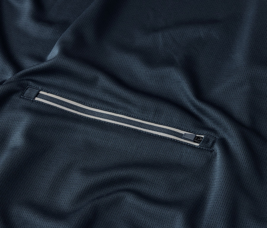 Detailný záber na tmavomodrú látku s vreckom na zips.