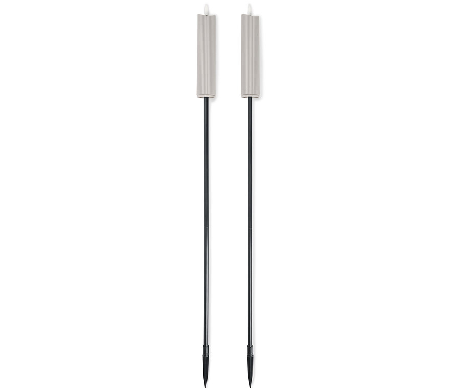 Dve béžové záhradné fakle s čiernymi tyčami stoja vedľa seba na bielom pozadí.