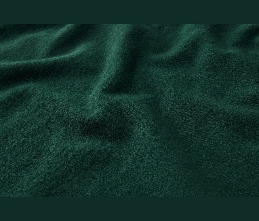 Tmavozelená, mäkká látka s jemnými záhybmi a textúrou.