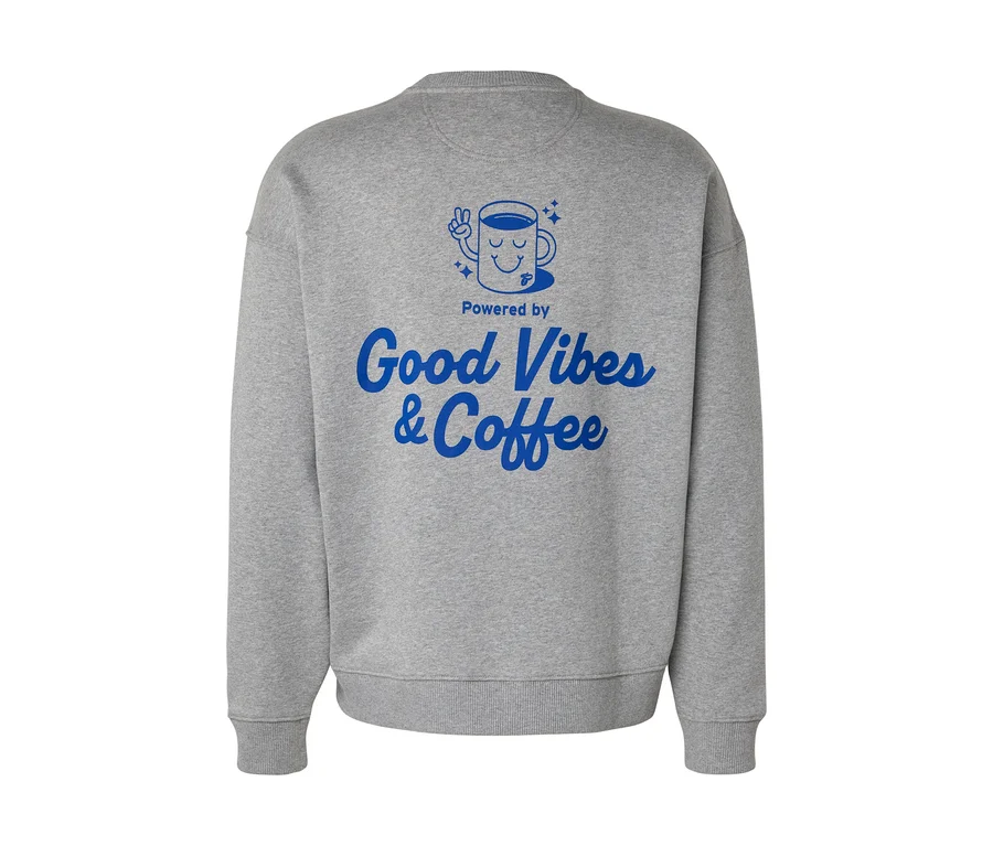 Sivá mikina Unisex Coffee Crew zozadu, s modrou potlačou šálky kávy s tvárou a nápisom "Powered by Good Vibes & Coffee".