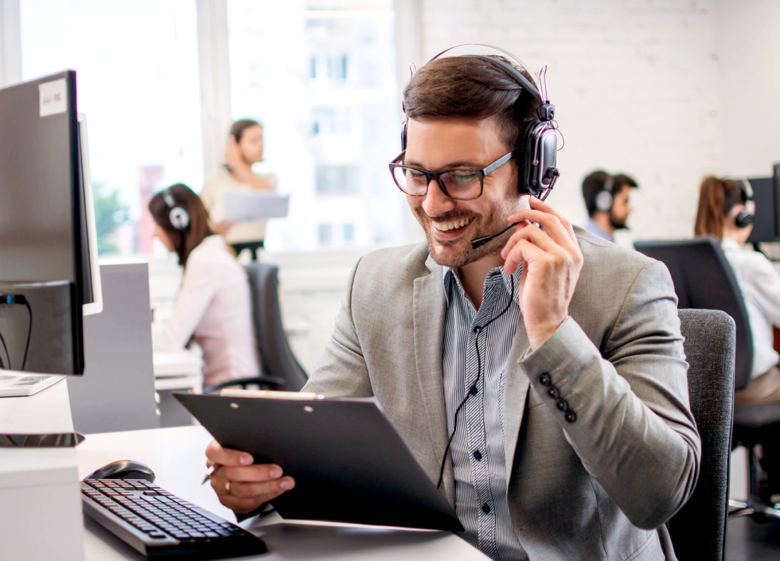 Ein Servicemitarbeiter sitzt am Telefon und beantwortet Fragen.