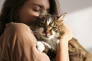 Eine Frau kuschelt mit einer Katze.