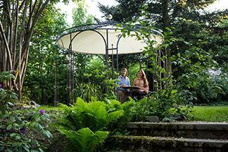 Ein Pavillon steht im Garten und bietet Schutz vor der Sonne.