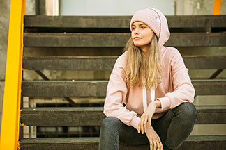 Ležérny coolový steet style outfit s mikinou, čiapkou, džínsami a teniskami.